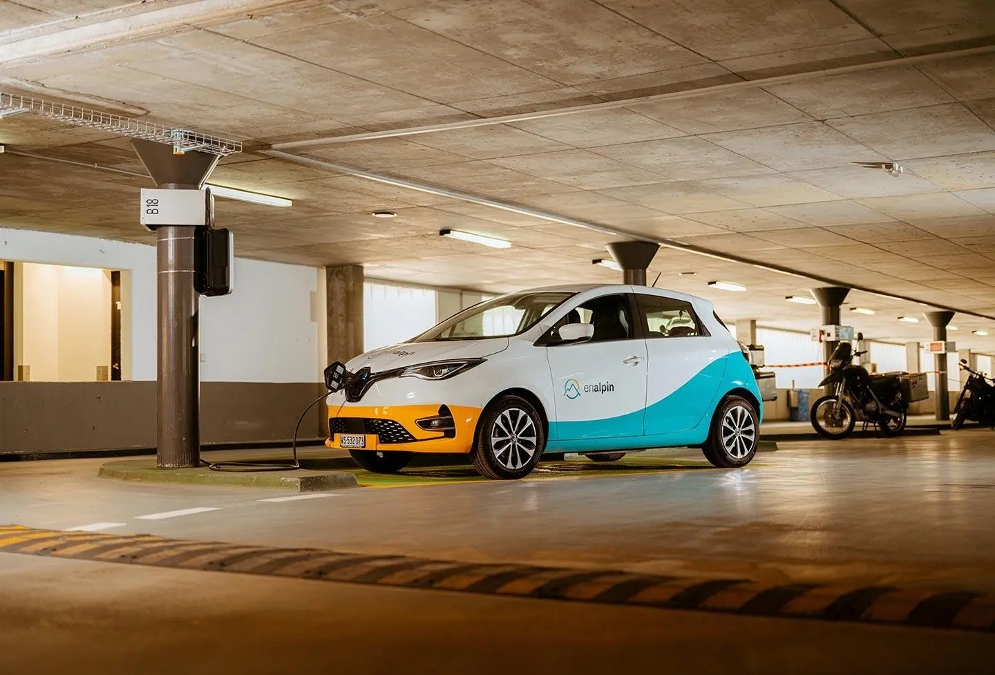 Voiture électrique à une borne de recharge dans un parking souterrain, comme exemple de mobilité électrique et d’utilisation de l’électricité