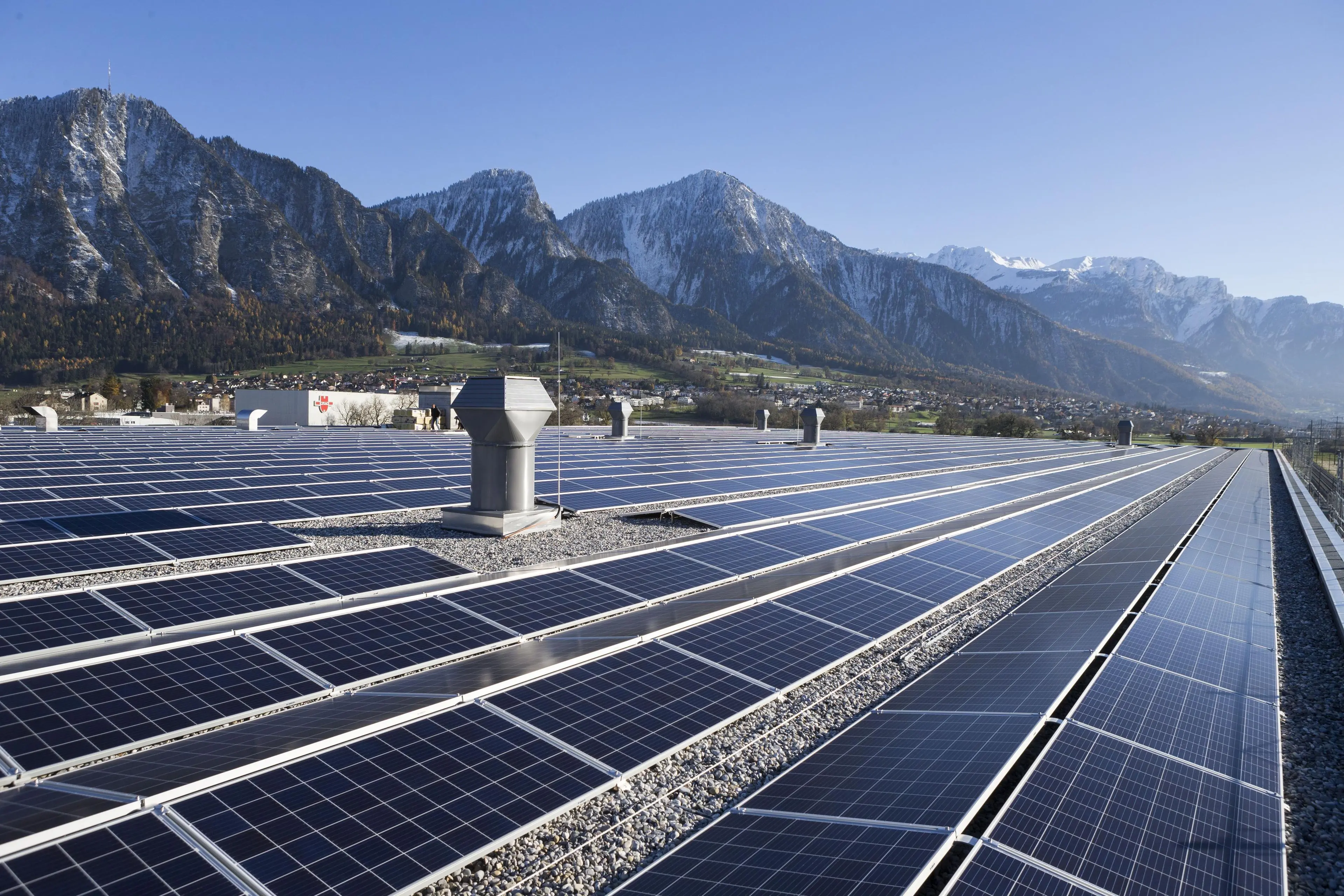 Installation photovoltaïque sur un grand toit avec les montagnes en arrière-plan