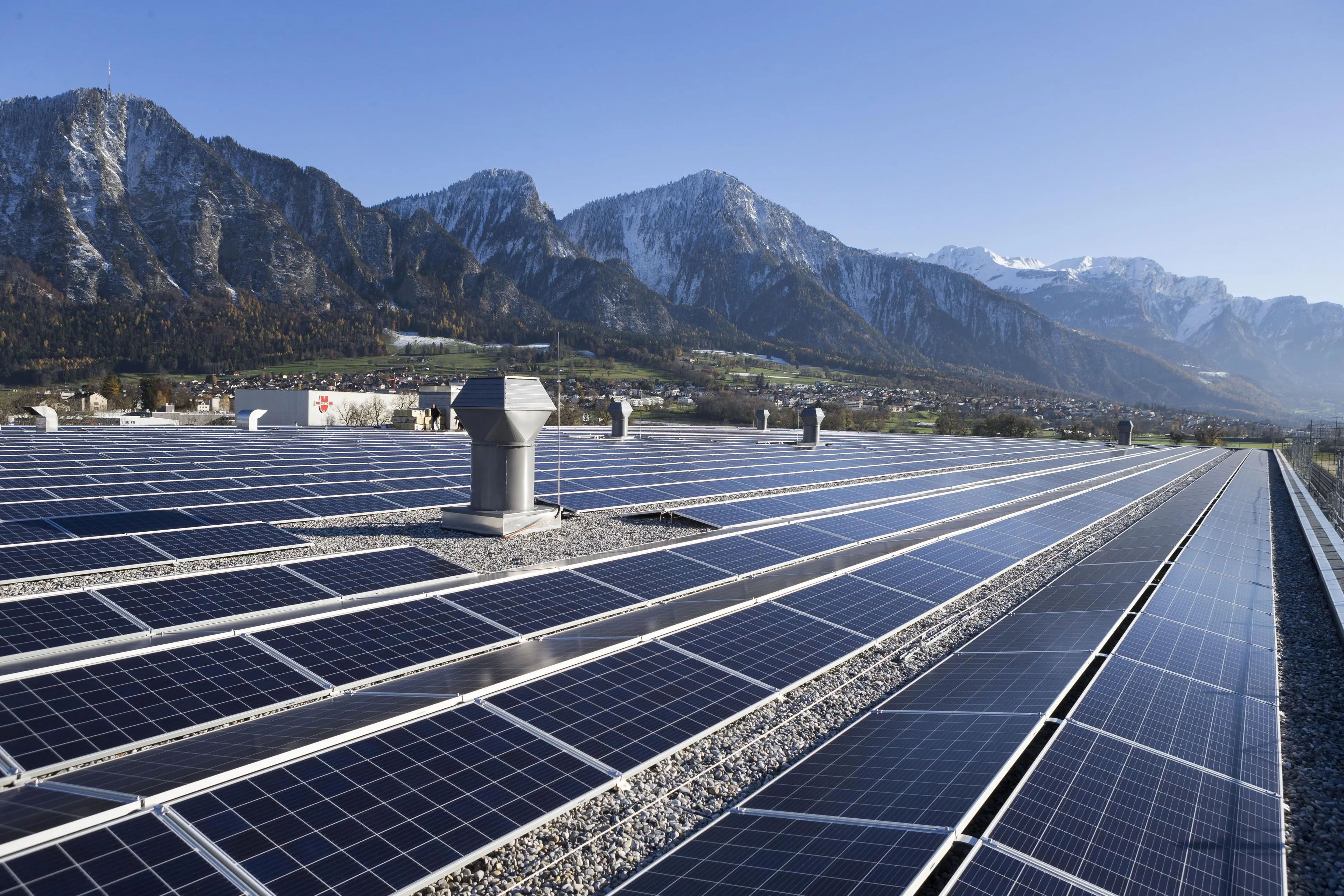 Photovoltaik Anlage auf grossen Dach mit Bergen im Hintergrund