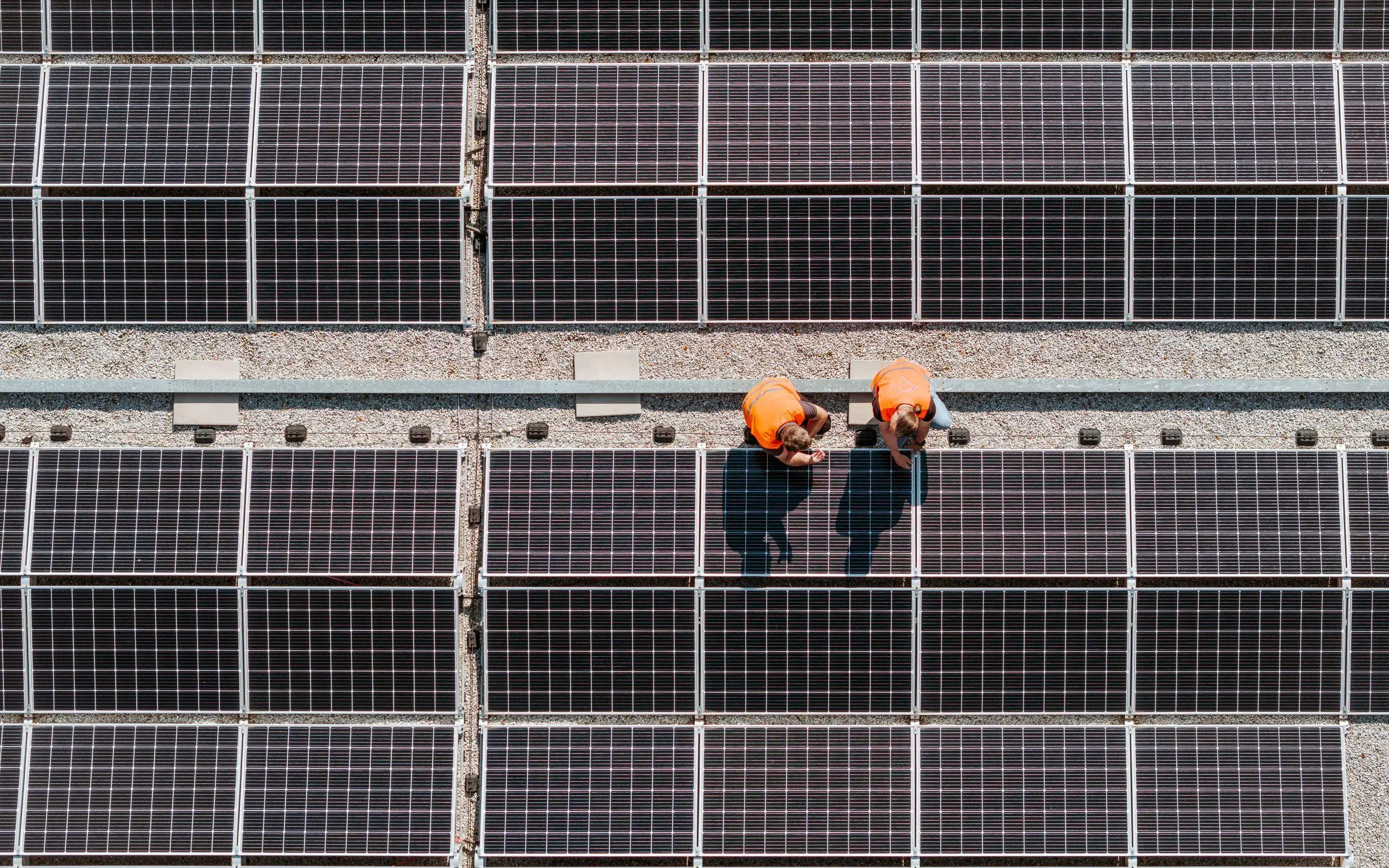 Zwei Arbeiter installieren PV-Anlage