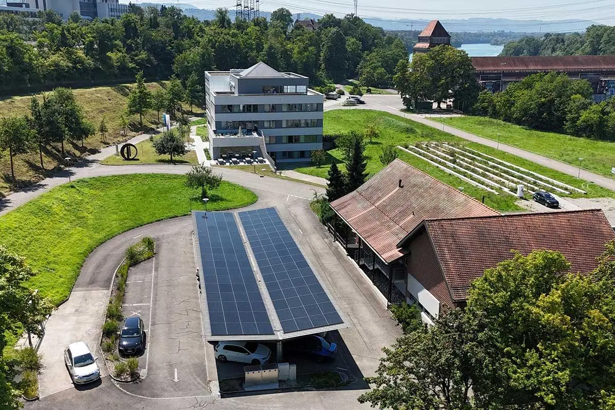 Garage mit Photovoltaikmodulen auf dem Dach und parkierten Autos darunter