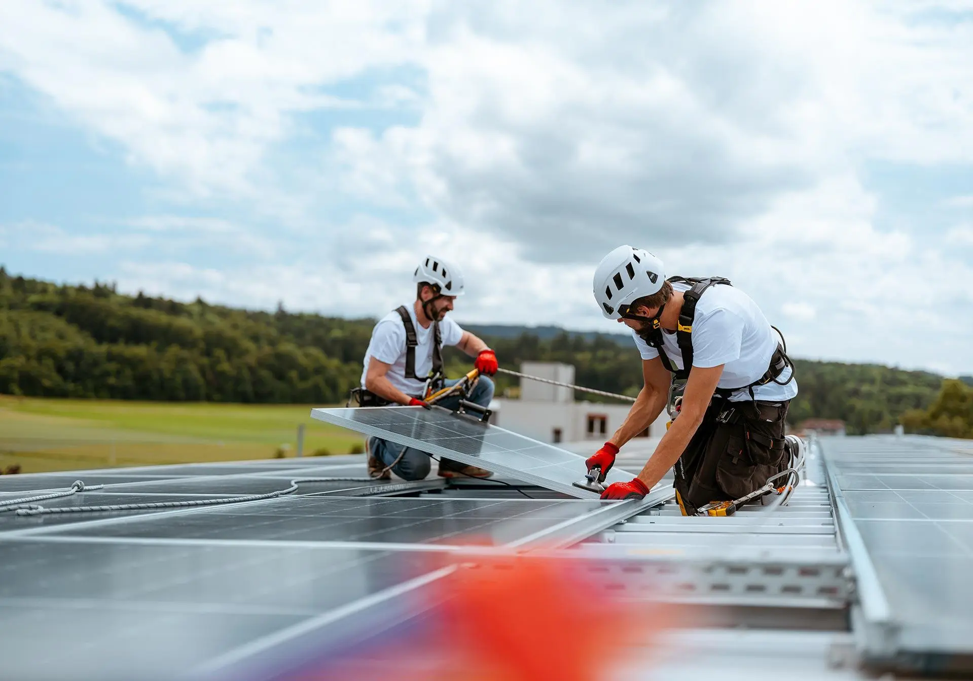 Des installateurs posent des modules solaires sur le toit d’une maison en Suisse