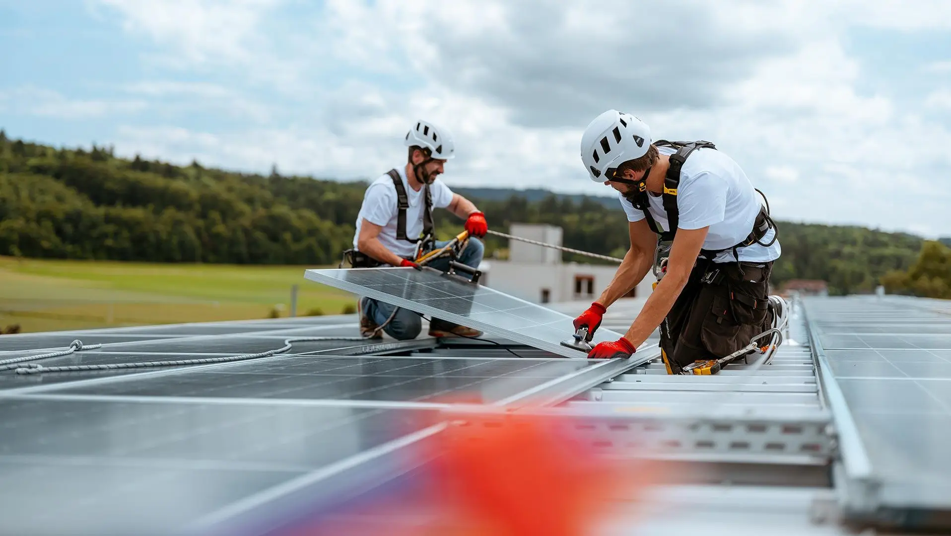 Monteure installieren Solarmodule auf einem Hausdach in der Schweiz