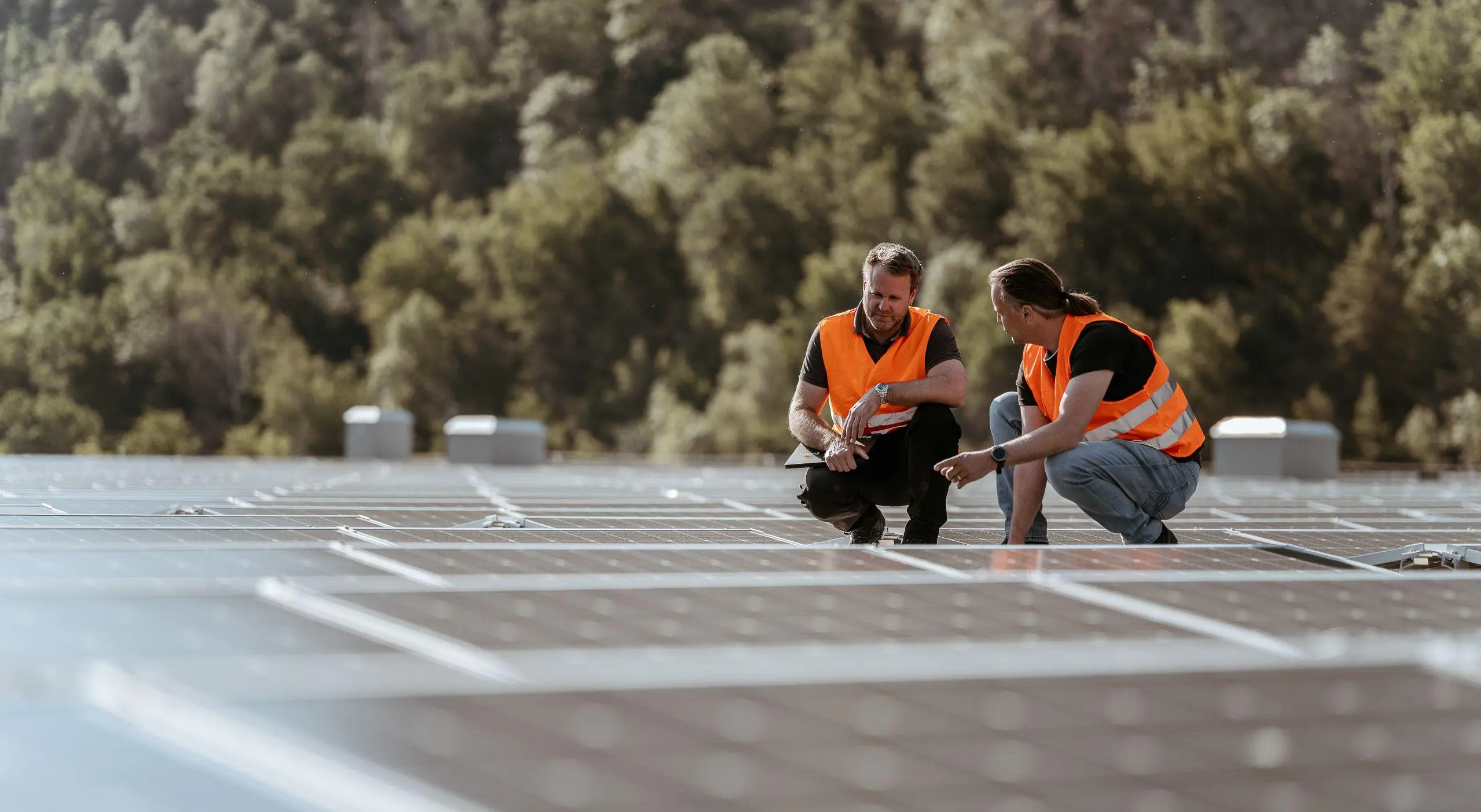 Deux ouvriers se trouvent sur un toit équipé d'une installation photovoltaïque