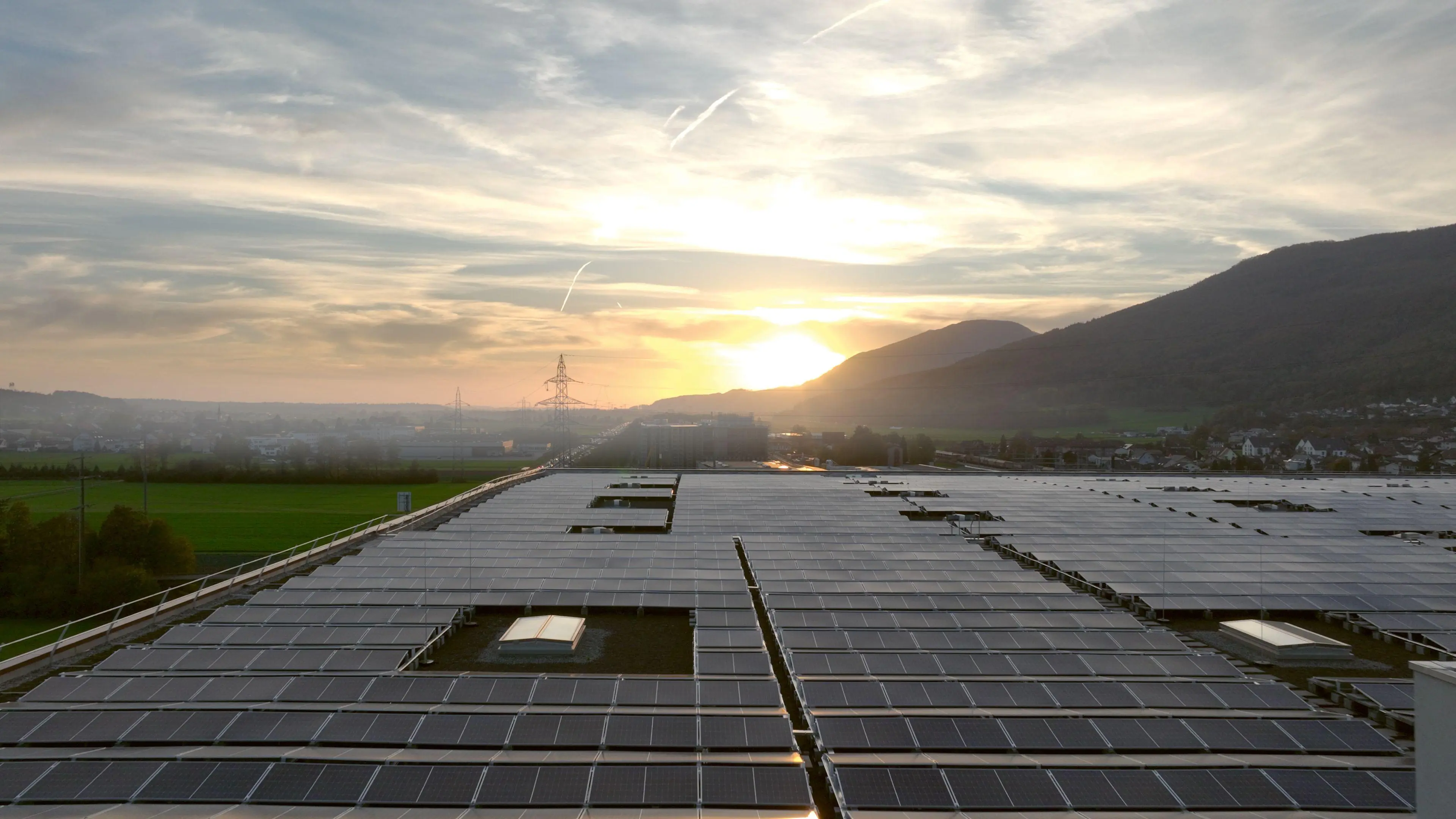 Grosses Dach mit PV Anlage und Sonnenuntergang