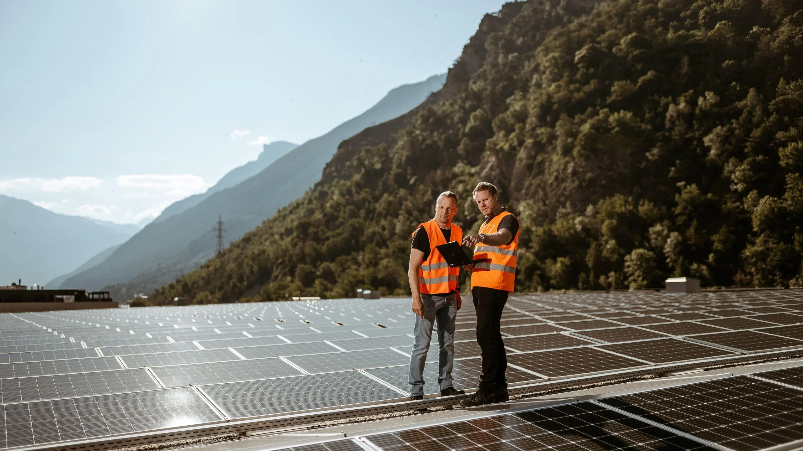 Zwei Arbeiter auf einem Dach mit Photovoltaikanlage