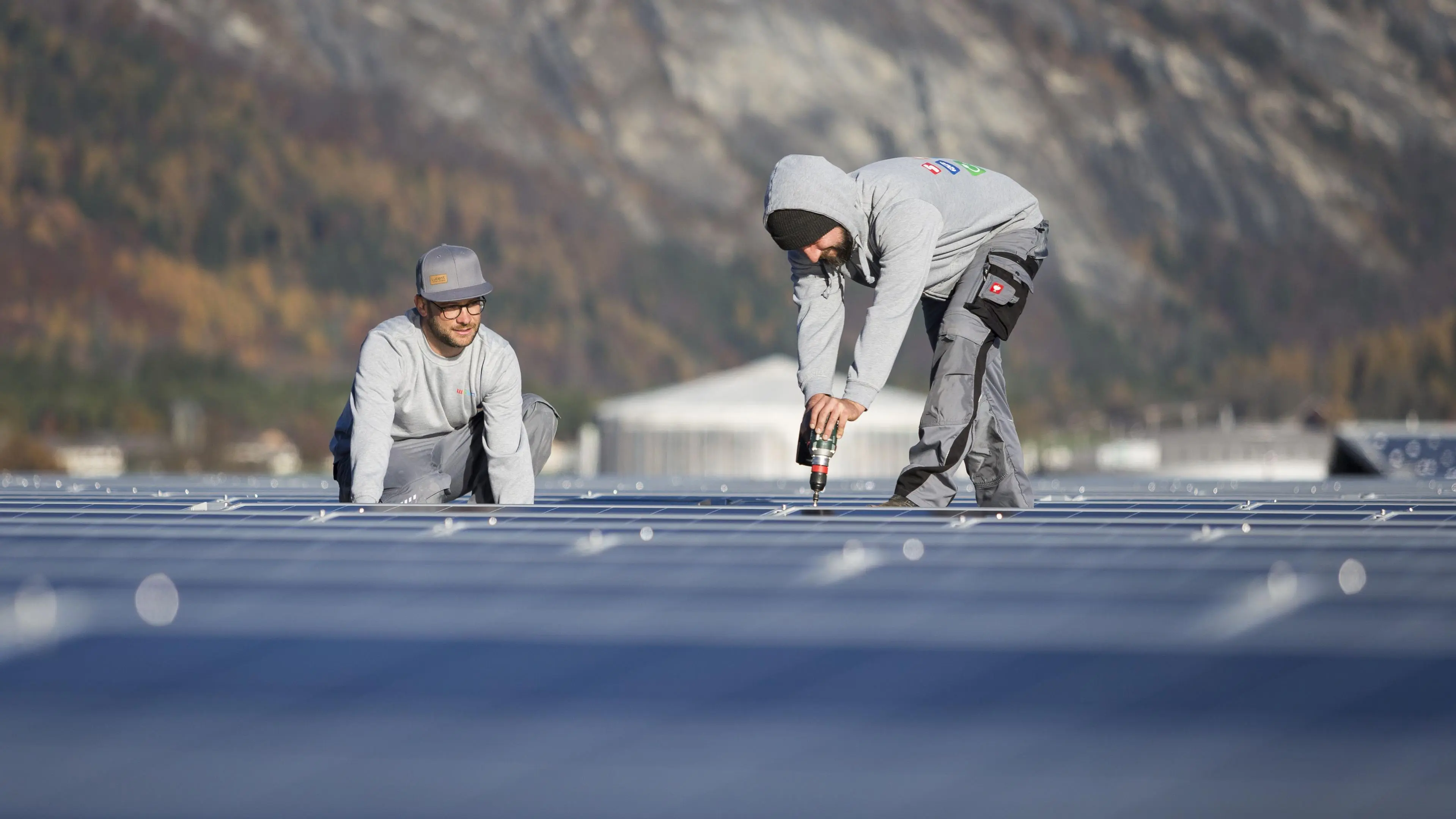 Zwei Arbeiter installieren PV-Anlage