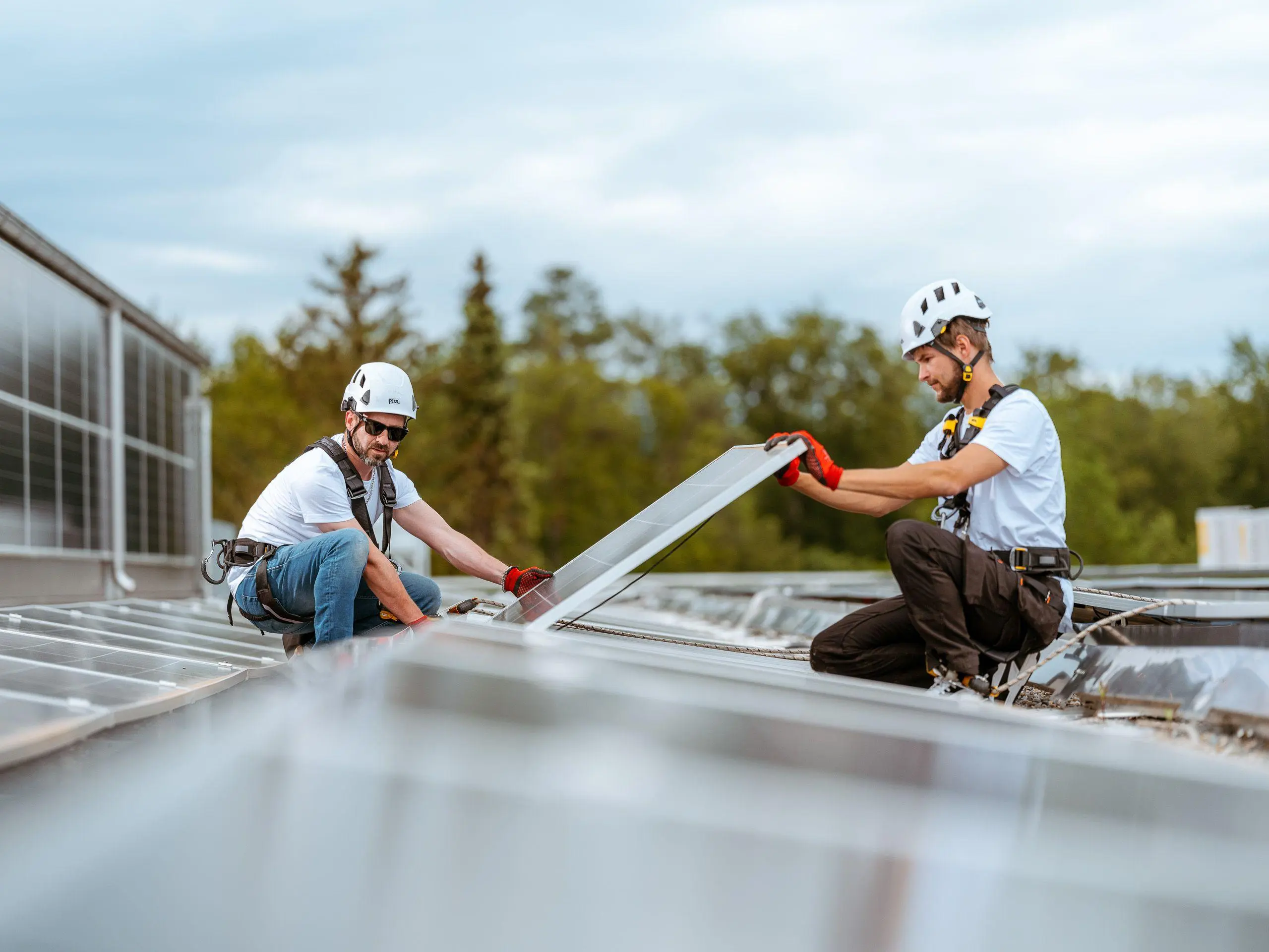 Deux installateurs montent des panneaux solaires sur un toit